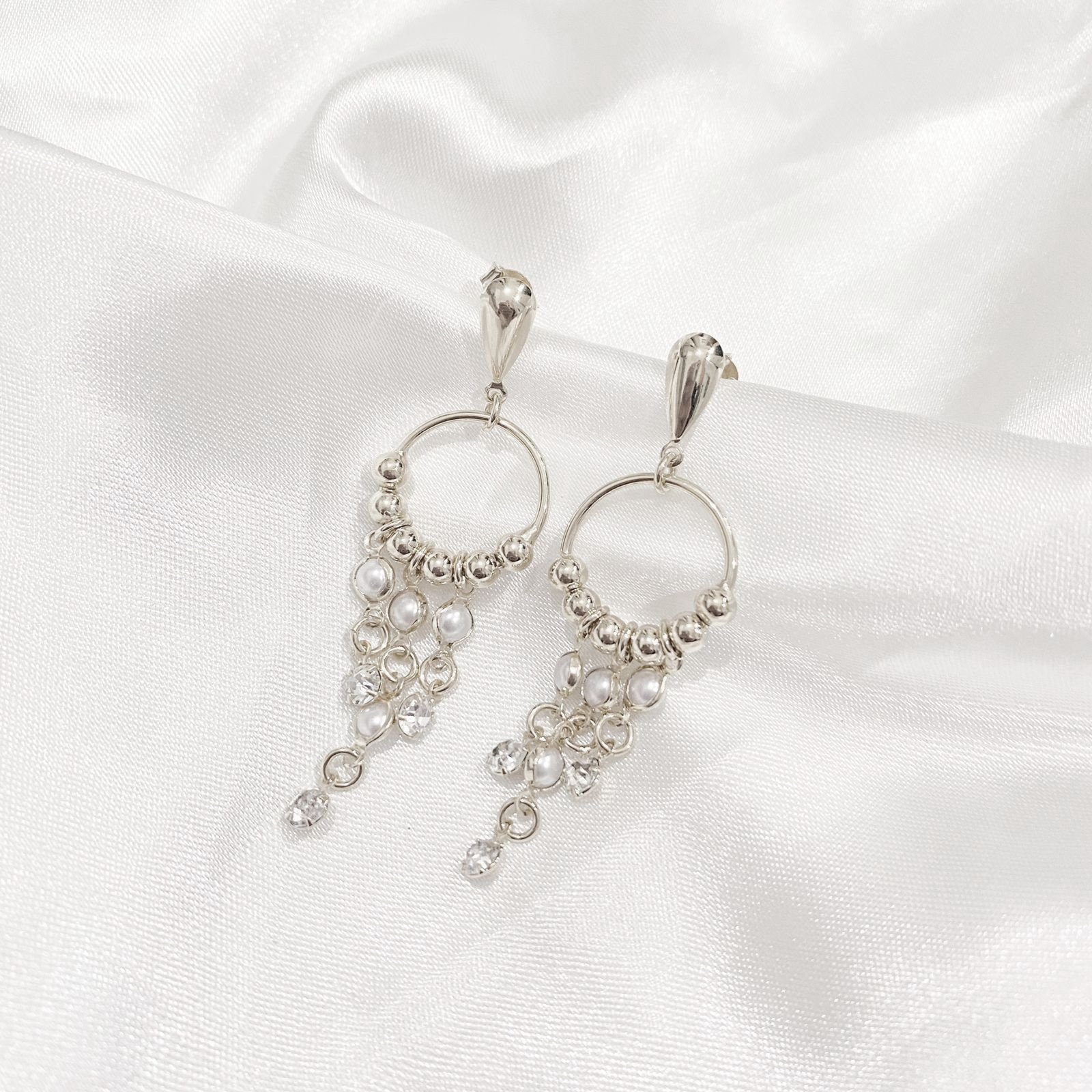 BRINCO ELO COM CASCATA DE PÉROLAS E PONTO DE LUZ EM RÓDIO BRANCO