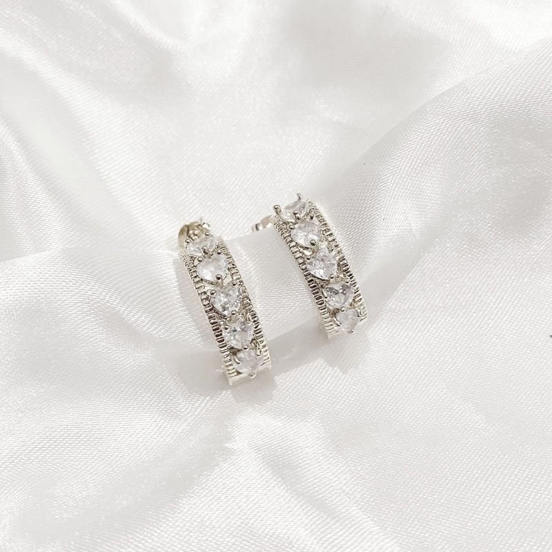 BRINCO MEIA ARGOLA TRABALHADA COM ZIRCONIAS CORAÇÃO EM RÓDIO BRANCO