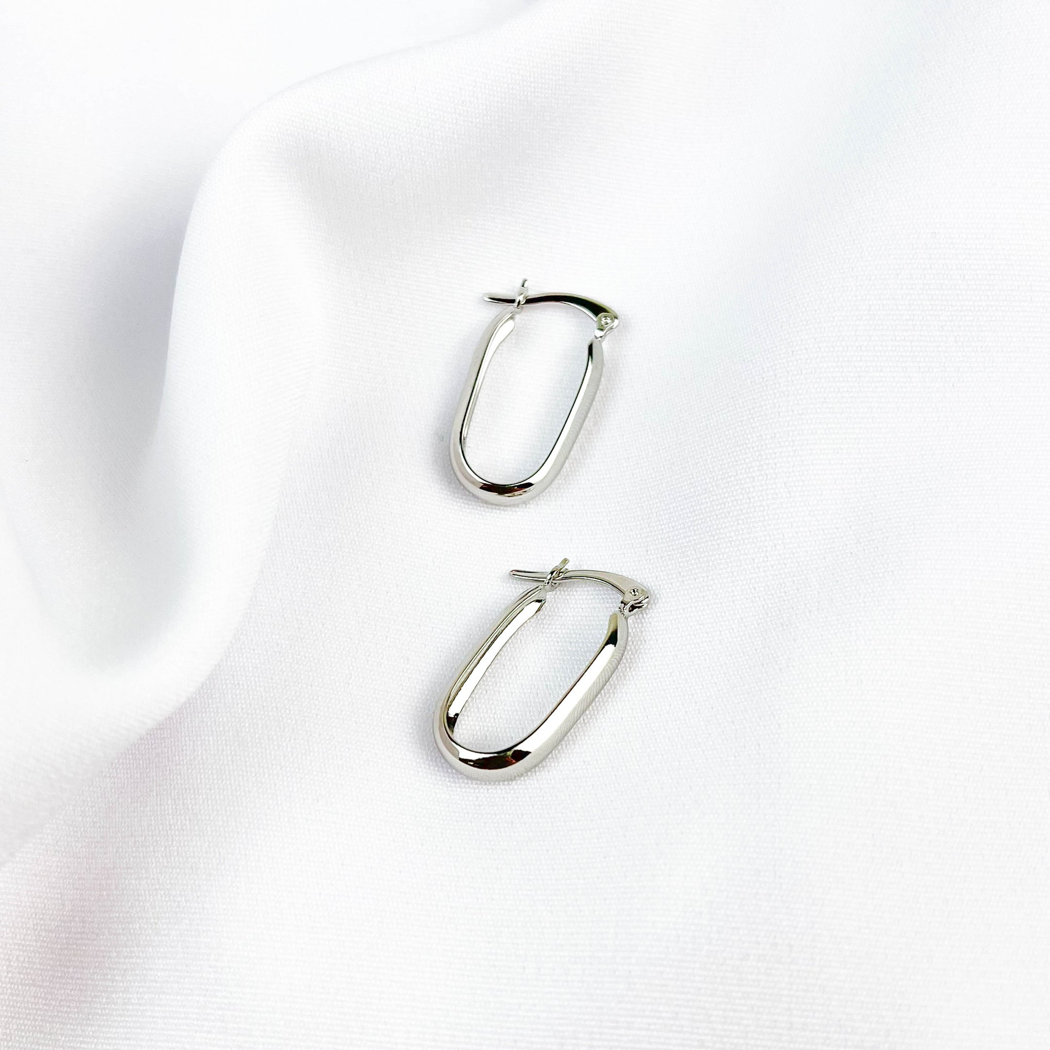 BRINCO OVAL TRAVA LISA EM RÓDIO BRANCO