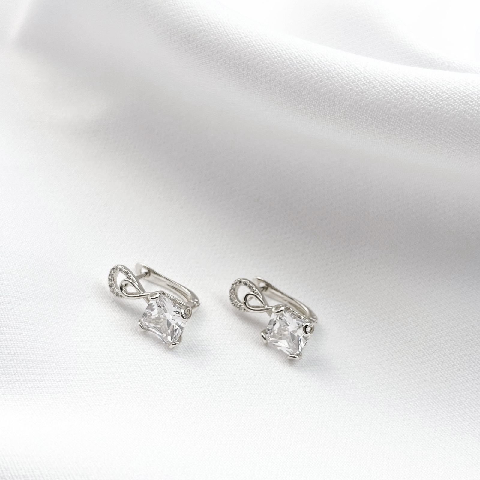 ARTICULADO COM DETALHE LAÇO EM ZIRCONIA E PEDRA QUADRADA EM RÓDIO BRANCO