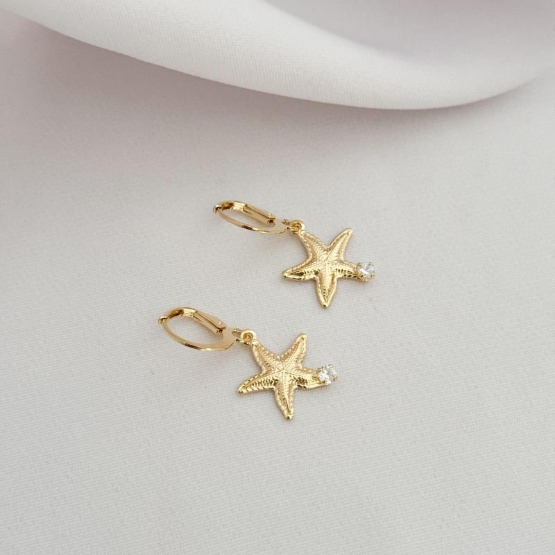 BRINCO ARTICULADO ESTRELA DO MAR E PONTO DE LUZ EM OURO 18K