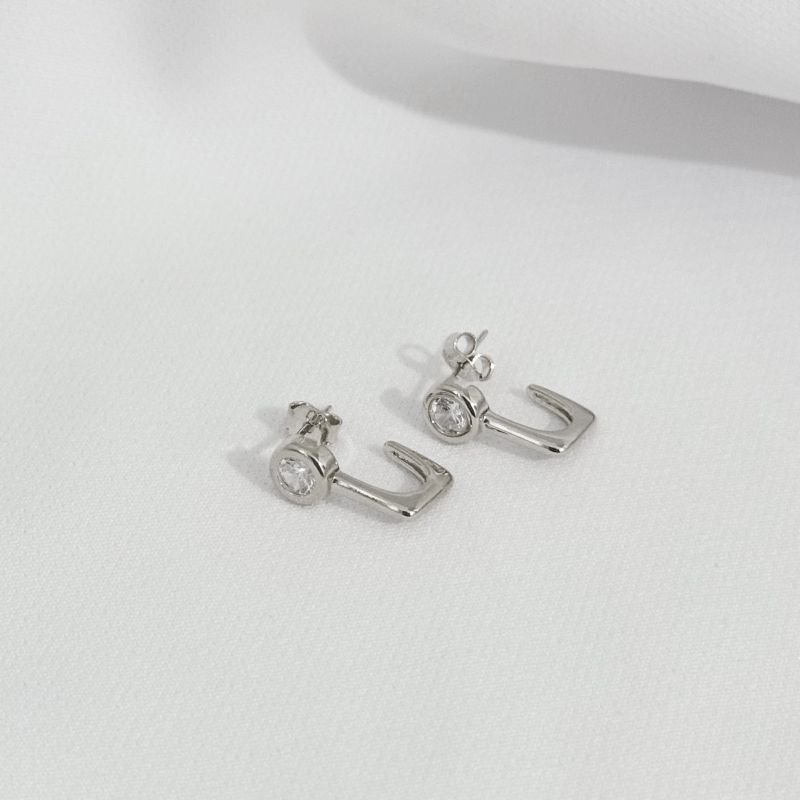 BRINCO FORMATO J COM PEDRA PONTA EM RÓDIO BRANCO