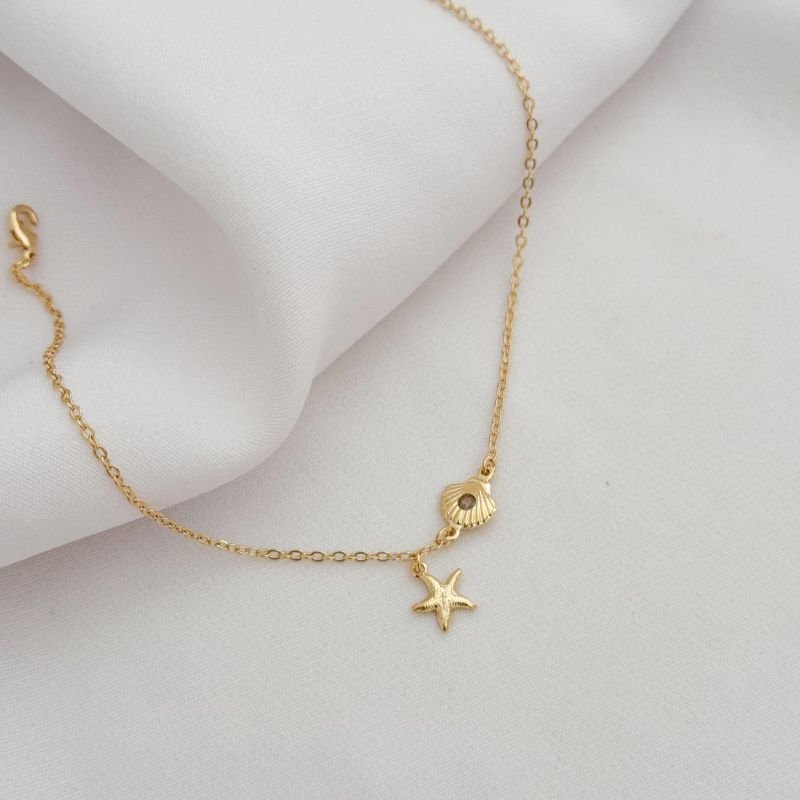 TORNOZELEIRA CONCHA E ESTRELA DO MAR EM OURO 18K