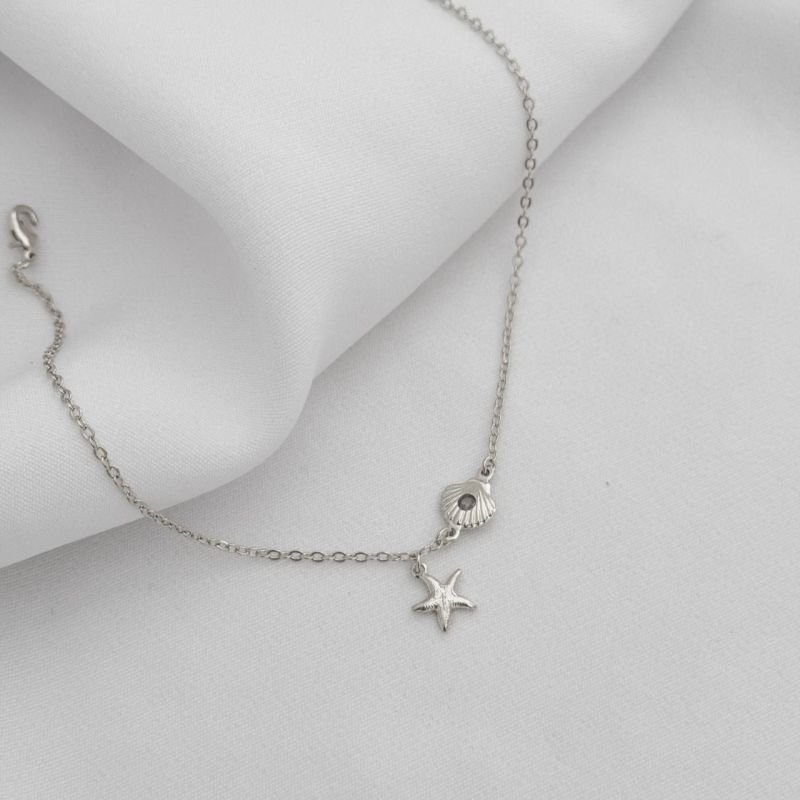 TORNOZELEIRA CONCHA E ESTRELA DO MAR EM RÓDIO BRANCO